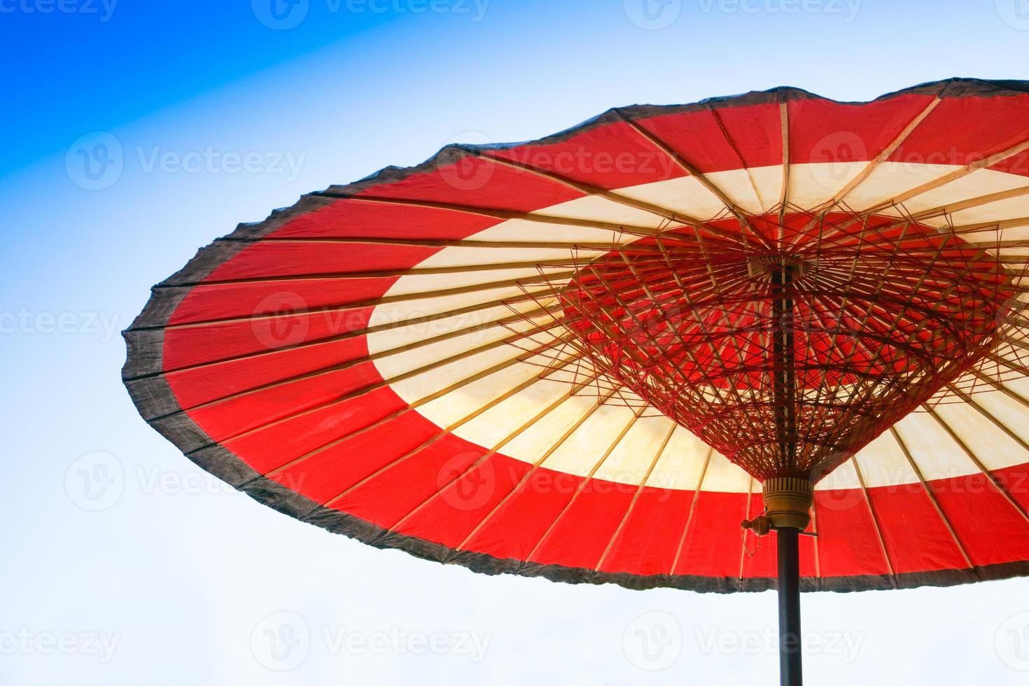 traditioneller chinesischer Regenschirm aus rotem und weißem Ölpapier auf blauem Himmelshintergrund foto