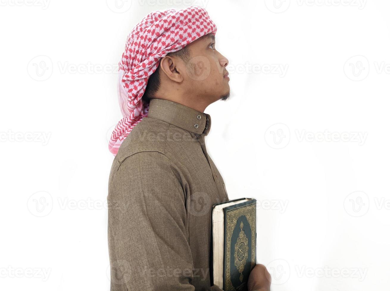 mann, der koran hält und liest. islamischer Hintergrund foto