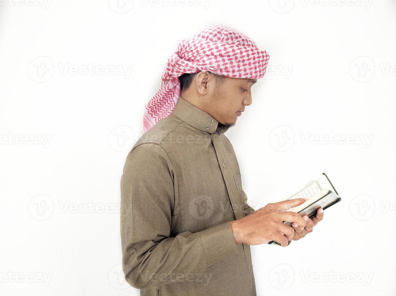 mann, der koran hält und liest. islamischer Hintergrund foto