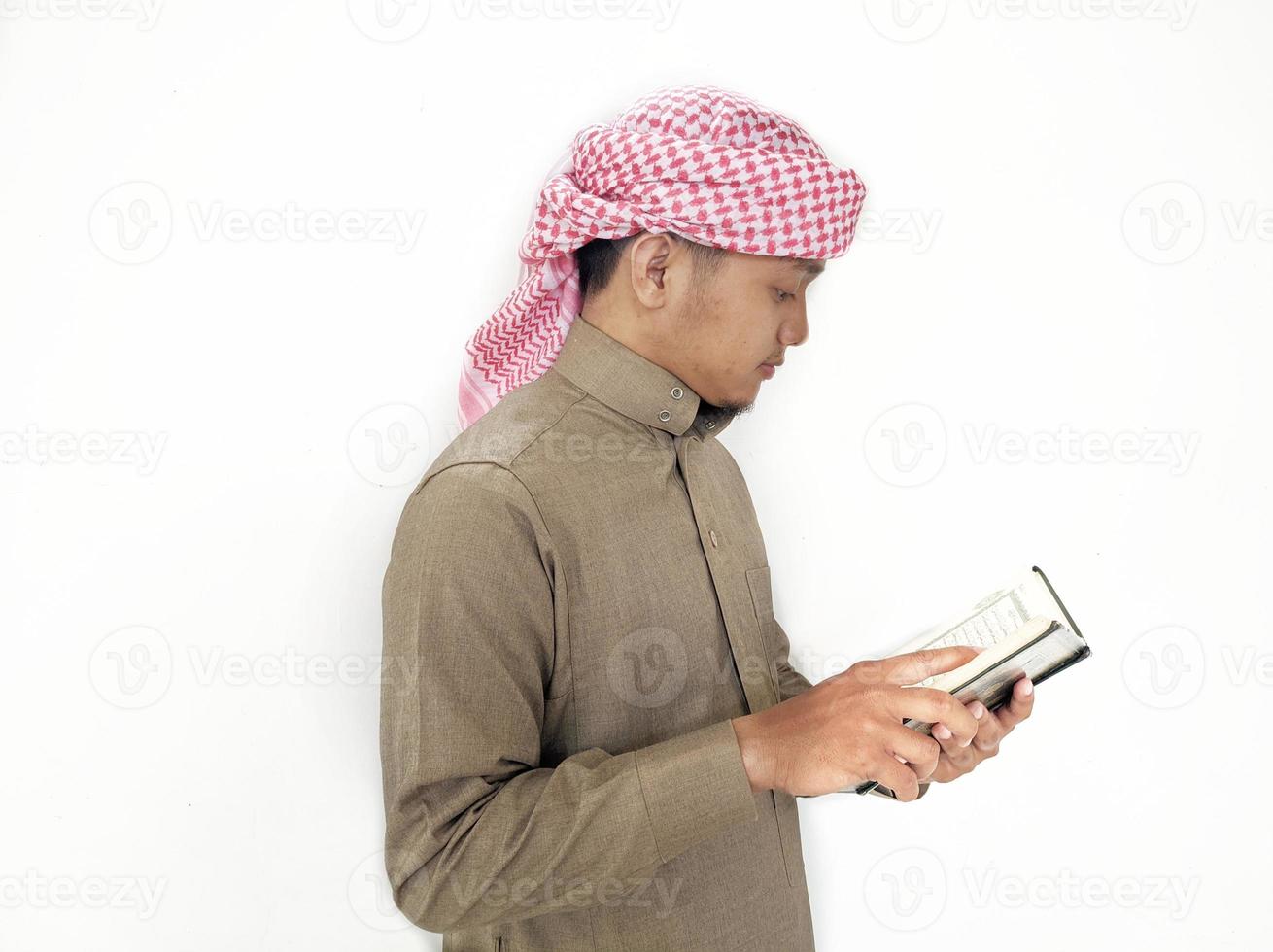 mann, der koran hält und liest. islamischer Hintergrund foto