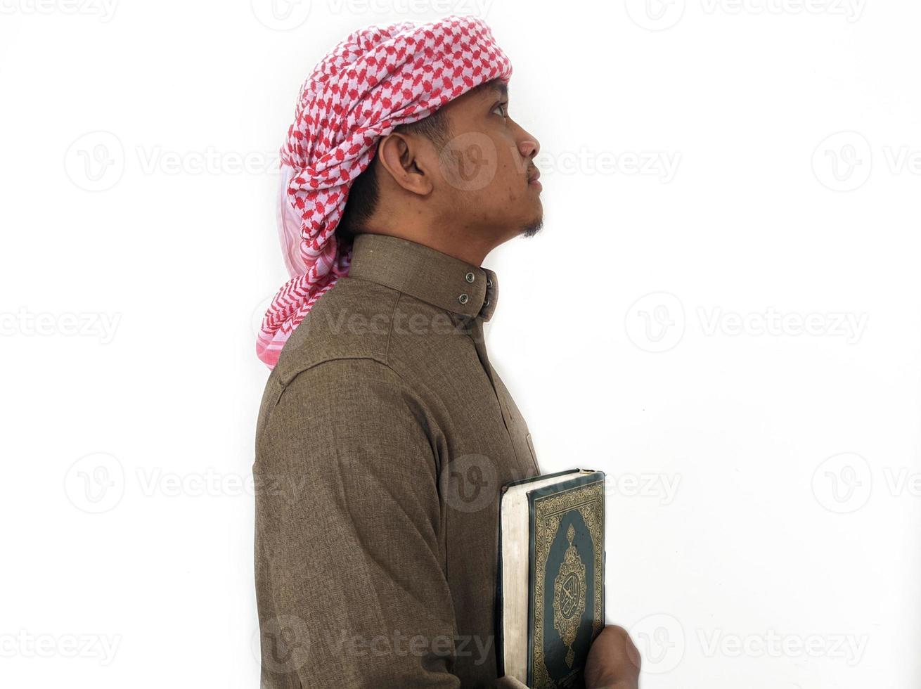 mann, der koran hält und liest. islamischer Hintergrund foto