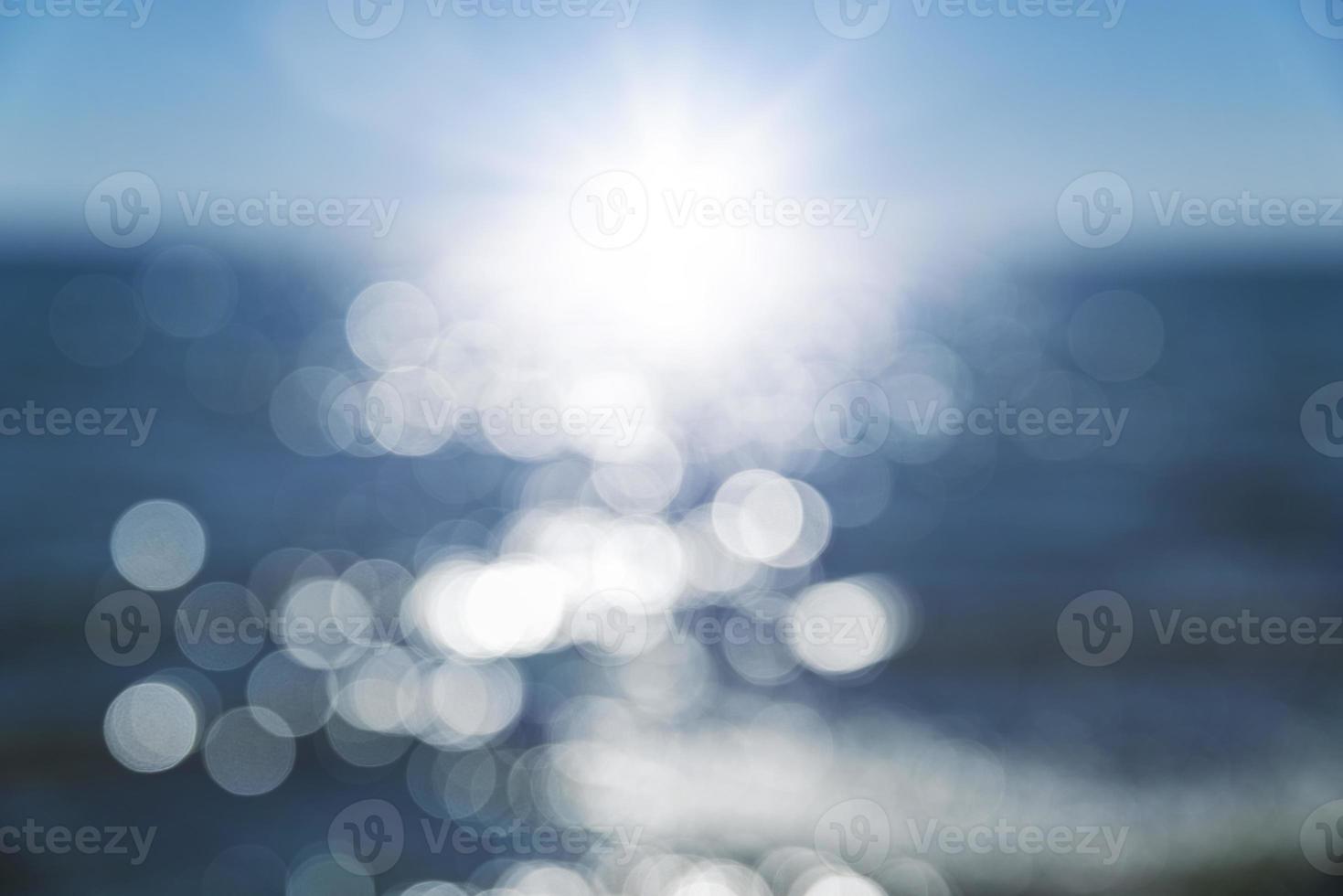 abstrakter unscharfer hintergrund mit blick auf das meer und eine helle sonne und strahlen foto