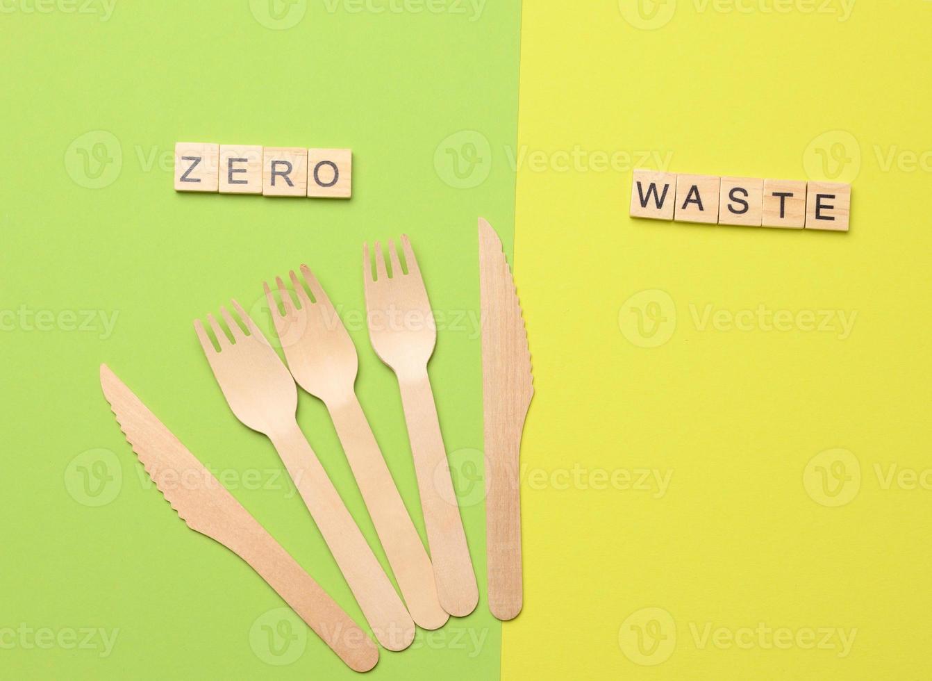 Einweg-Holzgabeln und Messer für Fast Food und Picknick auf grünem Hintergrund foto