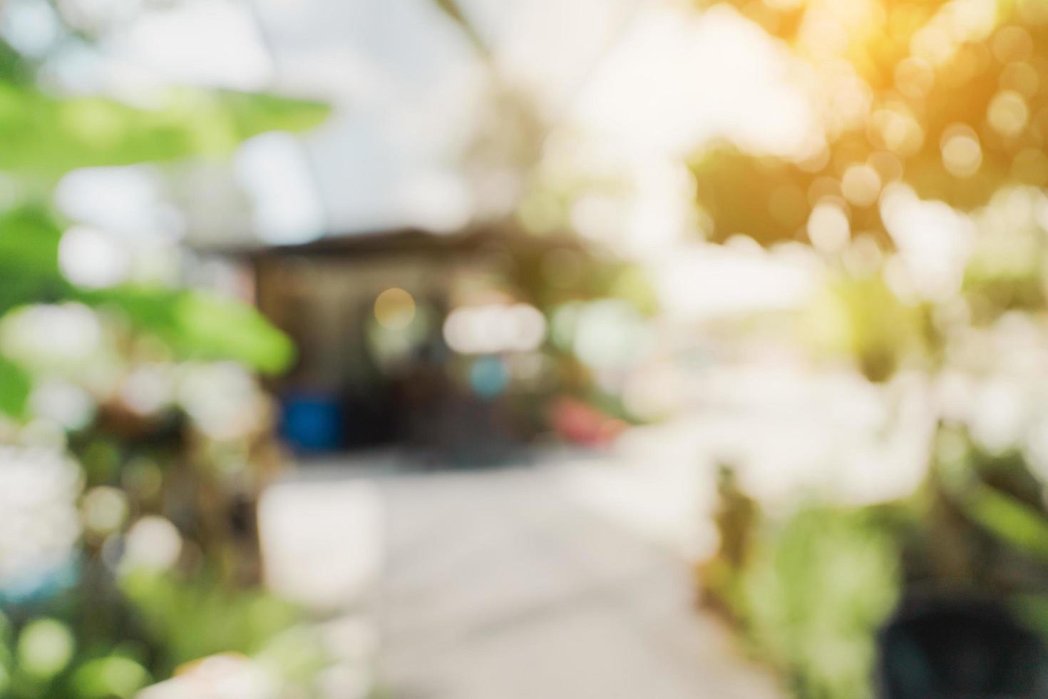 Defokussiertes Bokeh und unscharfer Hintergrund von Gartenbäumen im Café mit Sonnenlicht. foto