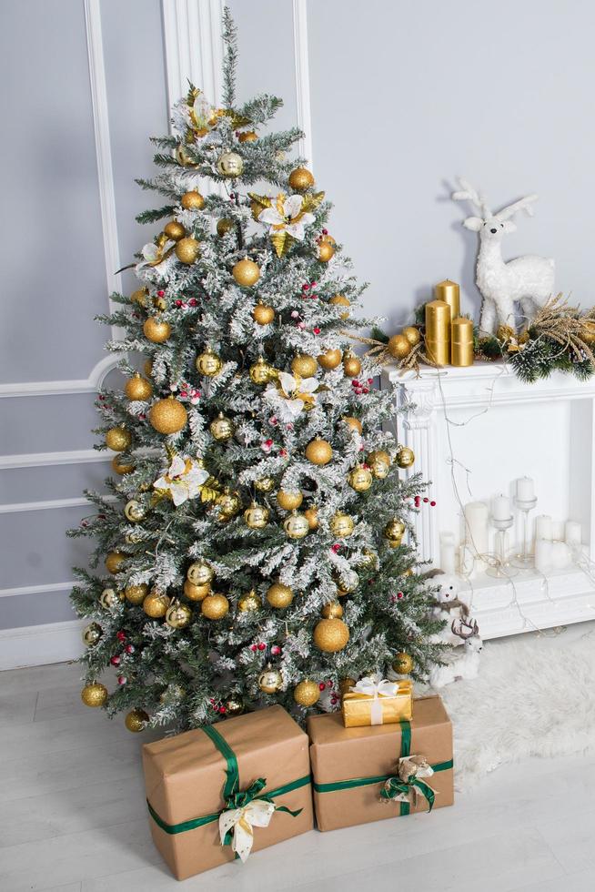 Weihnachtsbaum mit Dekor und Geschenken in einem weißen Raum foto