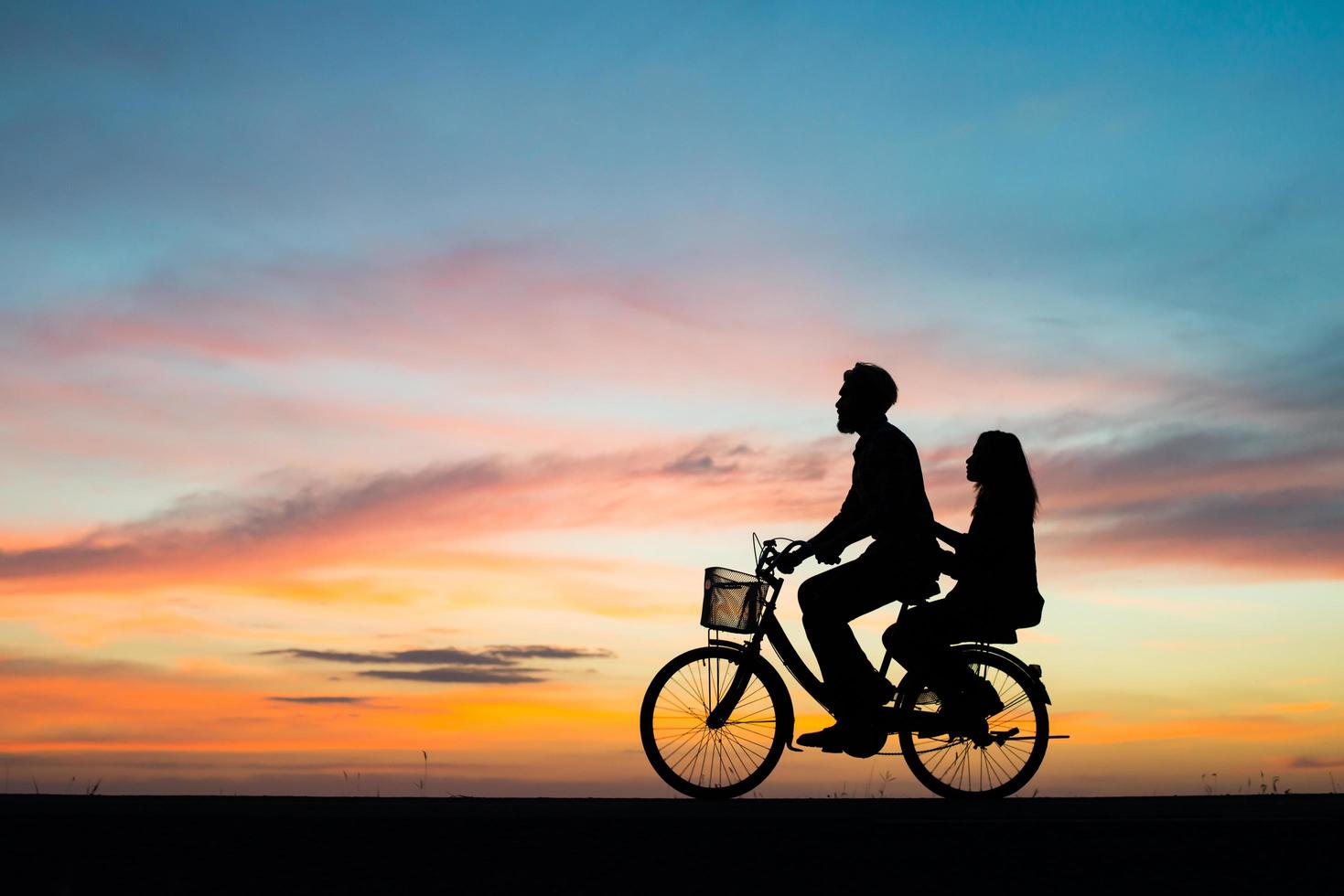 Silhouette des jungen Paares zusammen während des Sonnenuntergangs foto