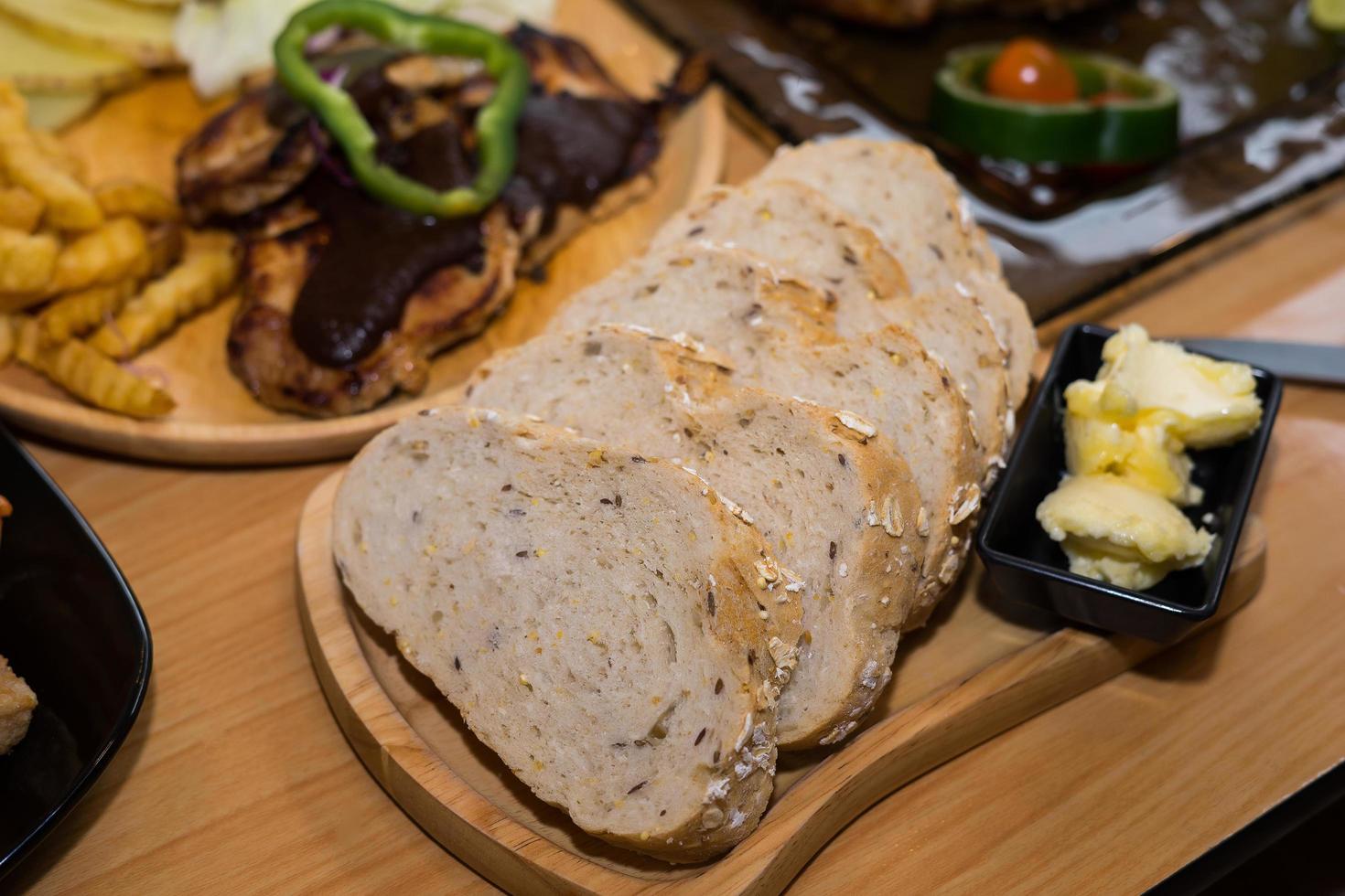 geschnittenes Brot mit Butter auf Holzteller foto