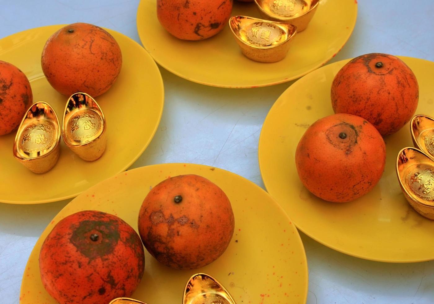 Teller mit Orangen und Goldbarren foto