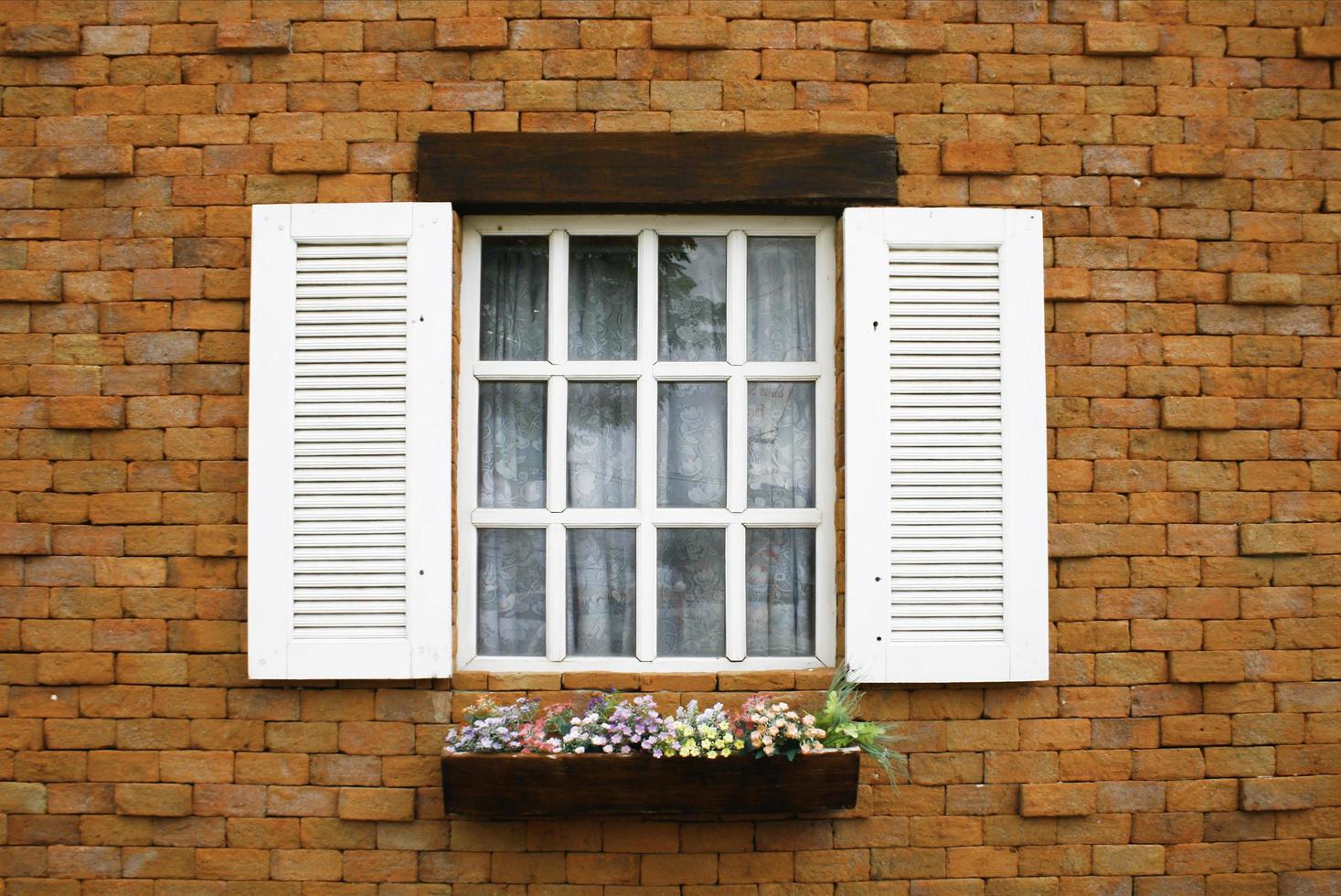 weiße Fensterläden und Blumen foto