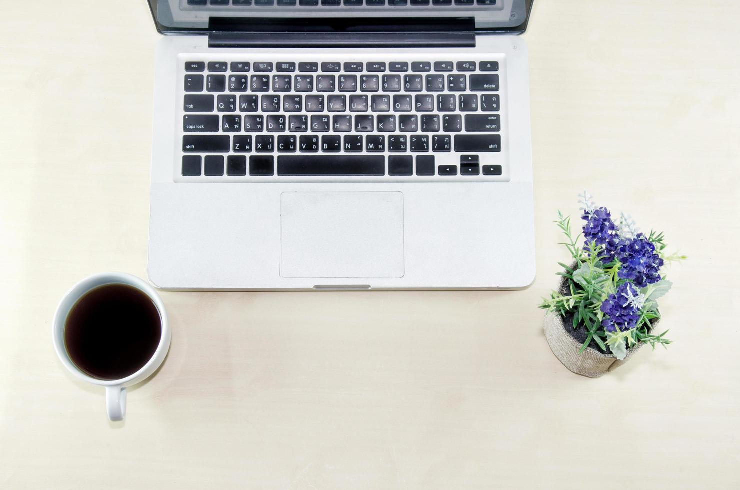 Laptop und Kaffee auf einem Schreibtisch foto