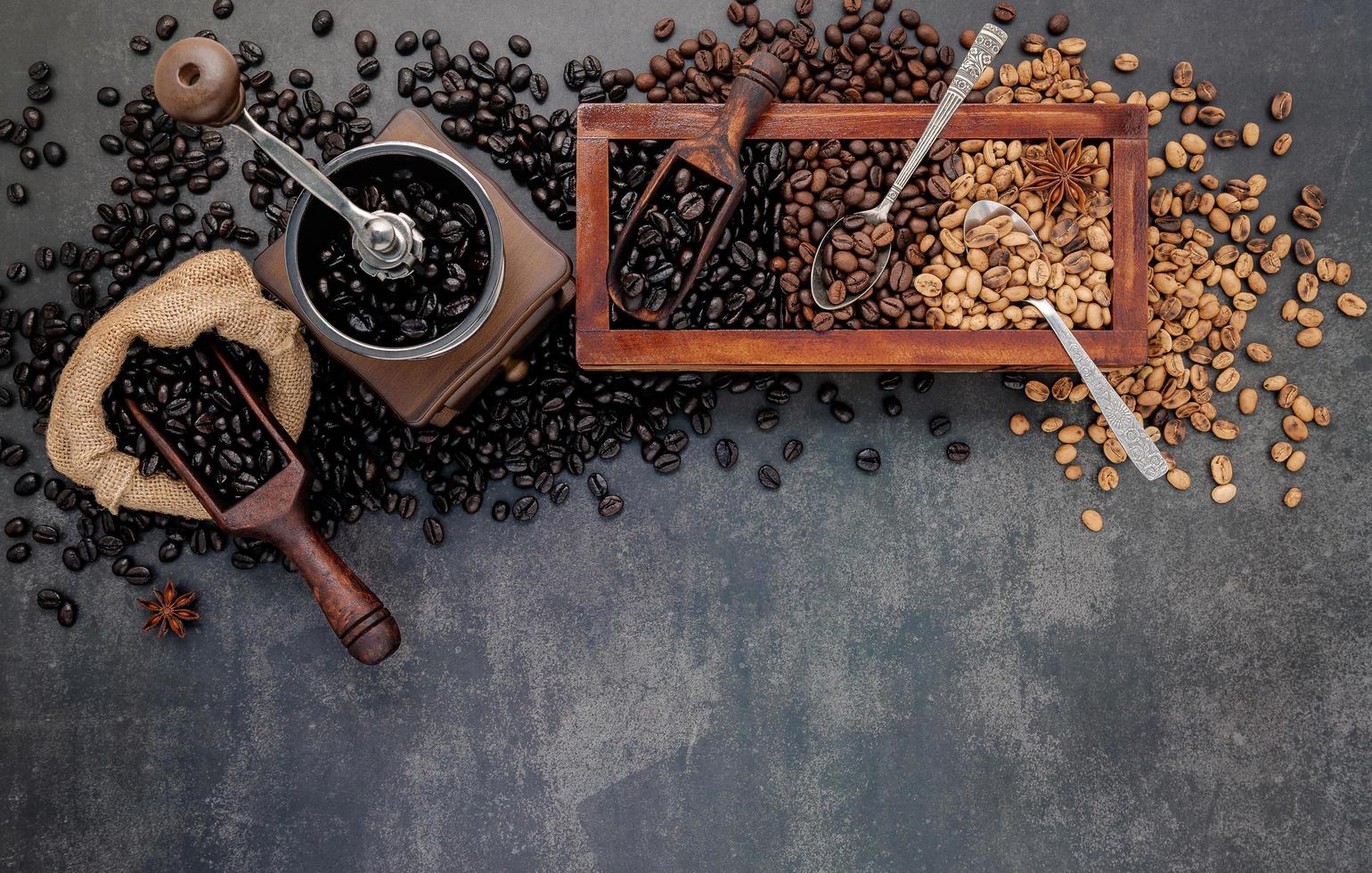 geröstete Kaffeebohnen mit Schaufel mit manueller Mühle foto