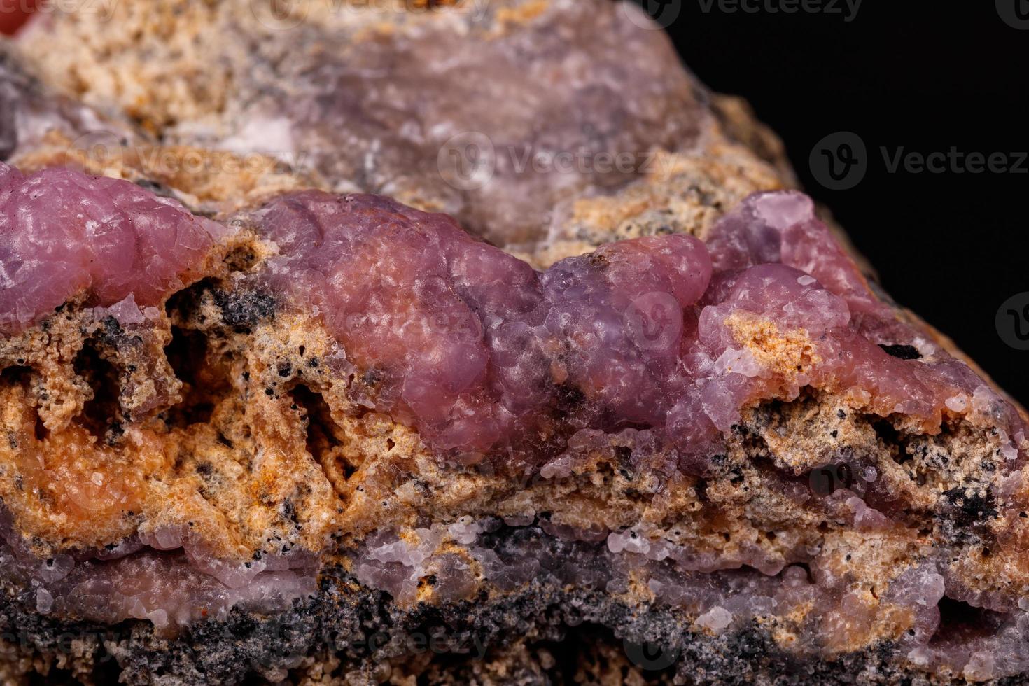 Makro Rosa Smithsonit Mineral Stein auf Mikroklin auf schwarz Hintergrund foto