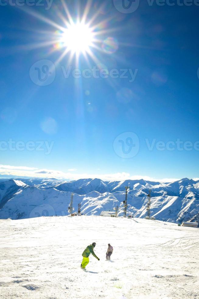 zwei freunde Snowboarder zurück Aussicht auf Urlaub im Ski Resort haben Spaß zusammen mit Blau Berg Hintergrund foto