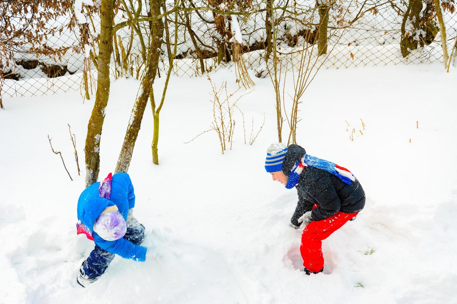 Zwei Jungen spielen Schneebälle, ein lustiges Spiel im Winter, eine glückliche Kindheit für Kinder. foto