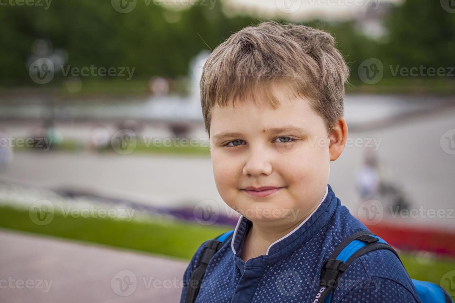 Porträt eines Kindes, eines Jungen vor dem Hintergrund urbaner Landschaften von Wolkenkratzern und Hochhäusern im Freien. Kinder, reisen. Lebensstil in der Stadt. Zentrum, Straßen. foto