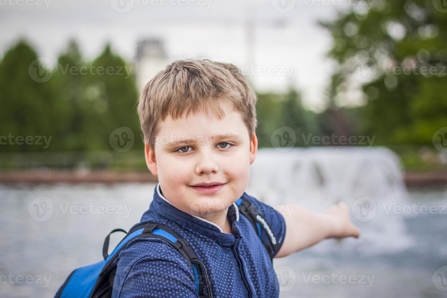 Porträt eines Kindes, eines Jungen vor dem Hintergrund urbaner Landschaften von Wolkenkratzern und Hochhäusern im Freien. Kinder, reisen. Lebensstil in der Stadt. Zentrum, Straßen. foto