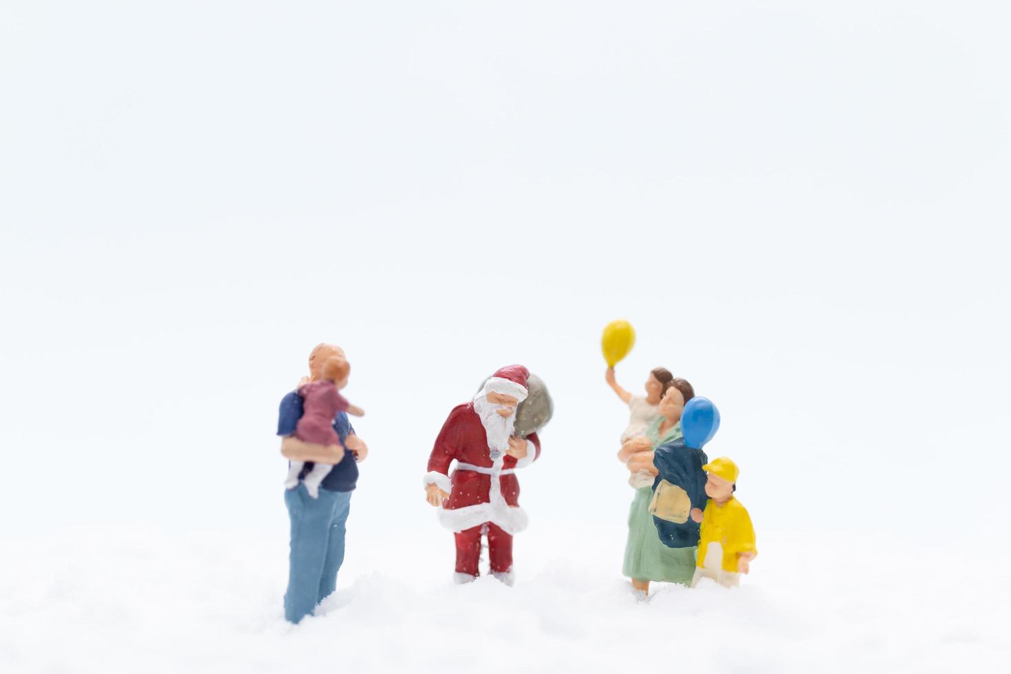 Miniaturfiguren von Weihnachtsmann und Kindern foto