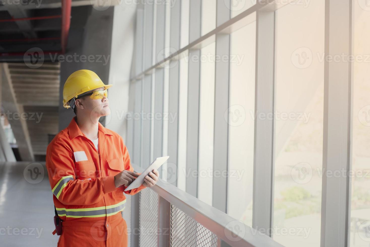 ingenieur oder vorarbeiter, der tablette hält. job details engineering site und arbeiten mit technologiekonzept. foto