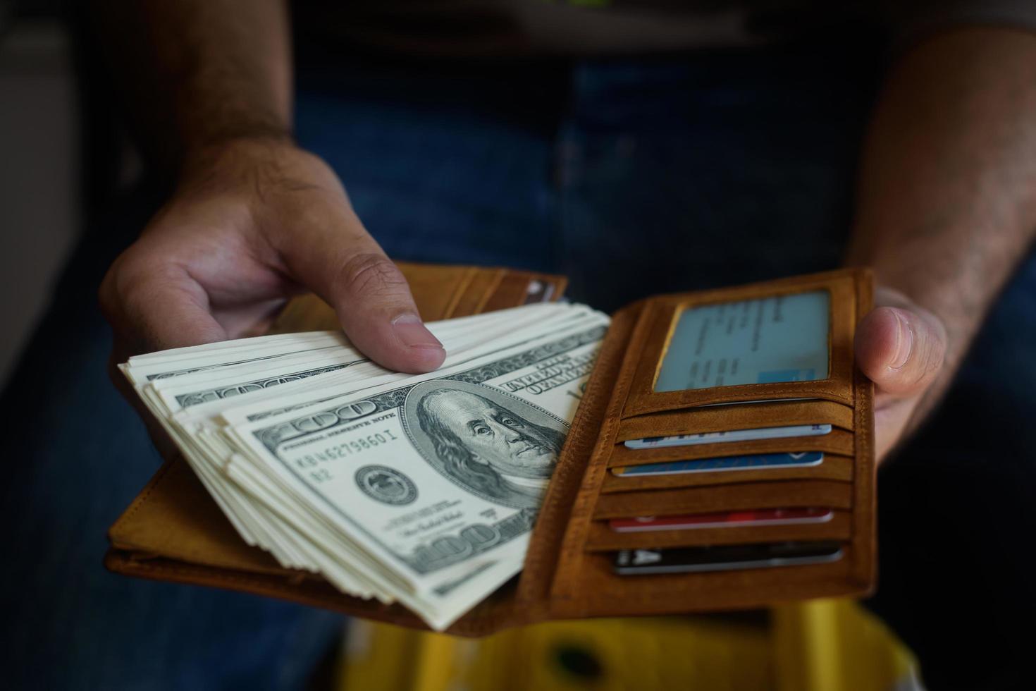 Hände nehmen Dollar aus der Brieftasche foto