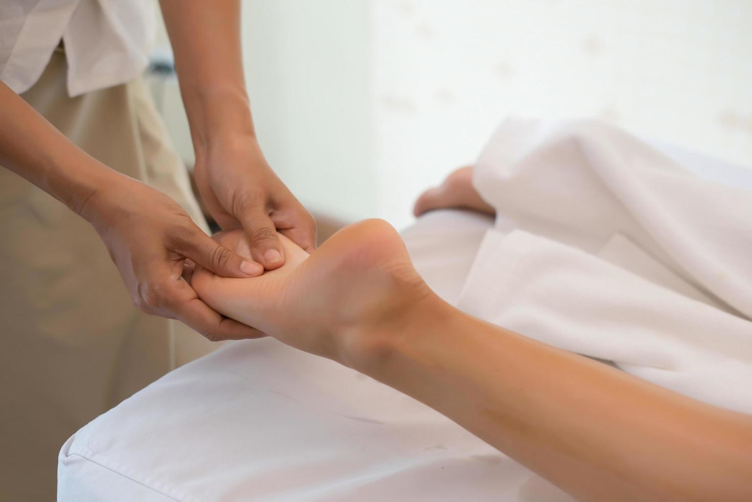 Nahaufnahme des Massagetherapeuten, der weibliches Bein im Spa-Salon massiert foto