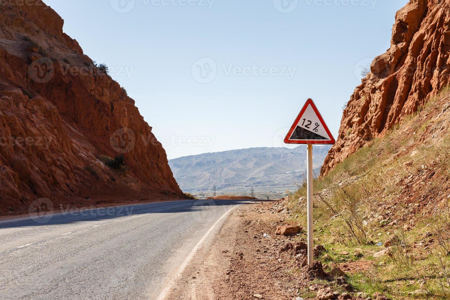 bergab Straße Zeichen mit Prozentsatz auf ein Berg Straße, Warnung der Verkehr Zeichen Kirgisistan foto