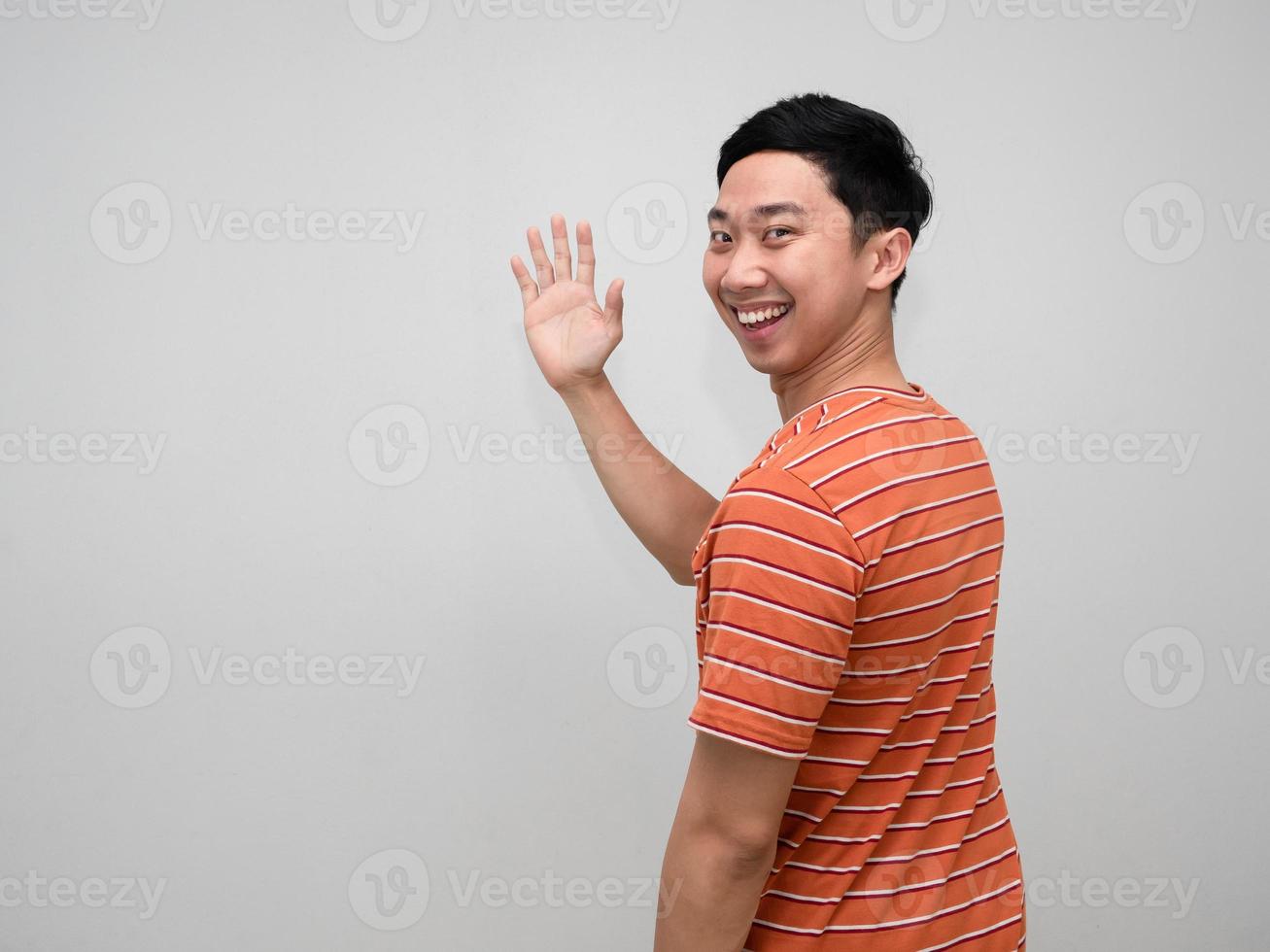 positiv Mann Orange gestreift Hemd heiter Lächeln Wende um zu Show Hand Hallo isoliert foto