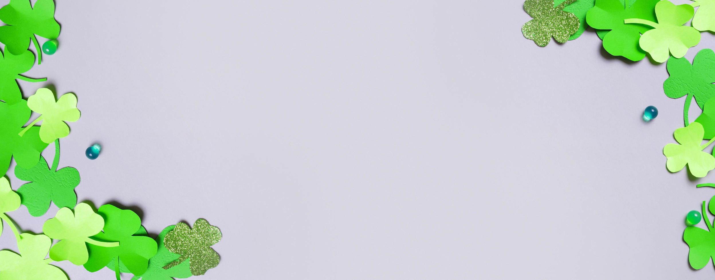 st. Patrick's Tag minimalistisch Banner Hintergrund. Papier Kleeblatt Blätter auf grau Hintergrund mit Kopieren Raum foto