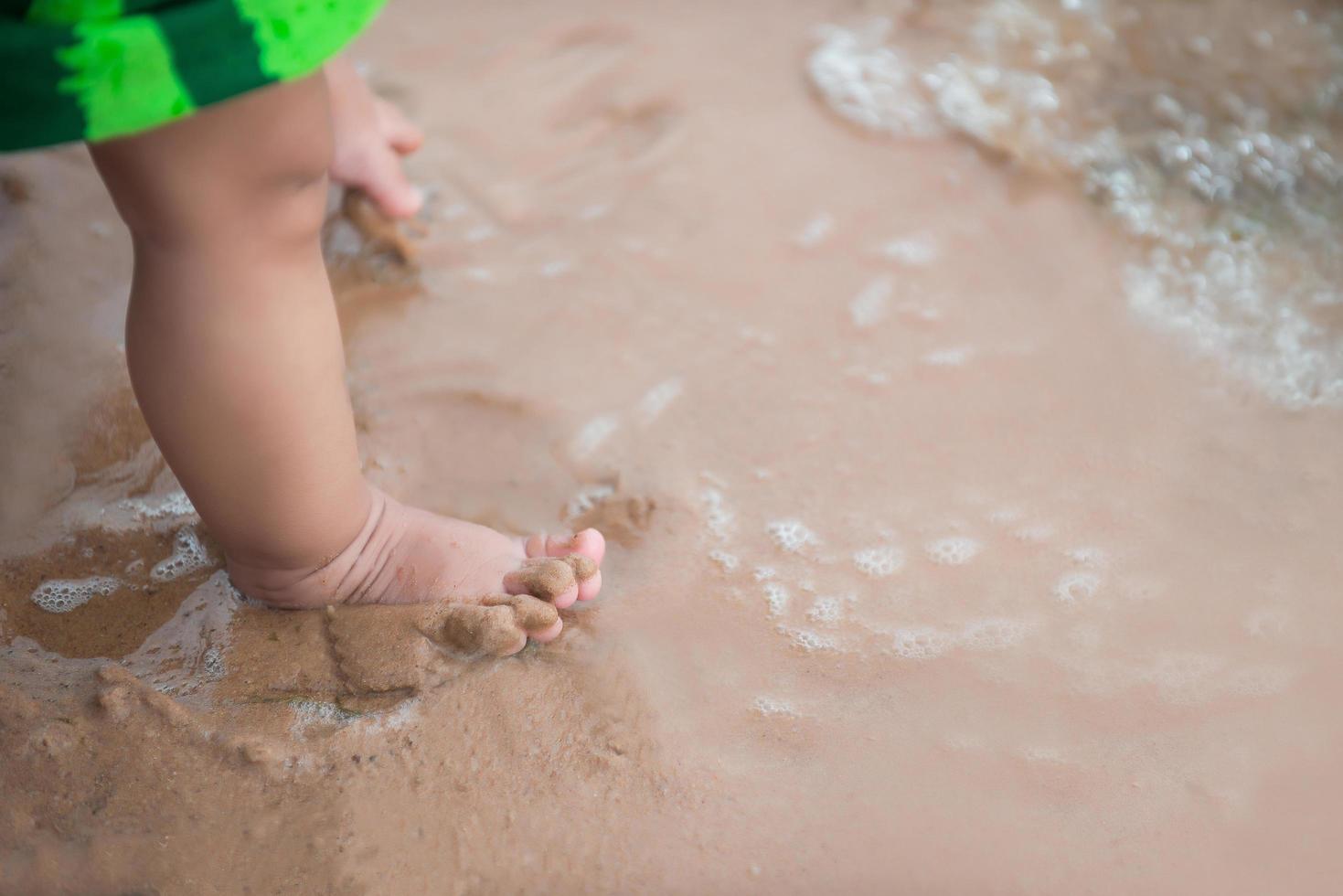 Beine eines Jungen, der am Strand steht foto