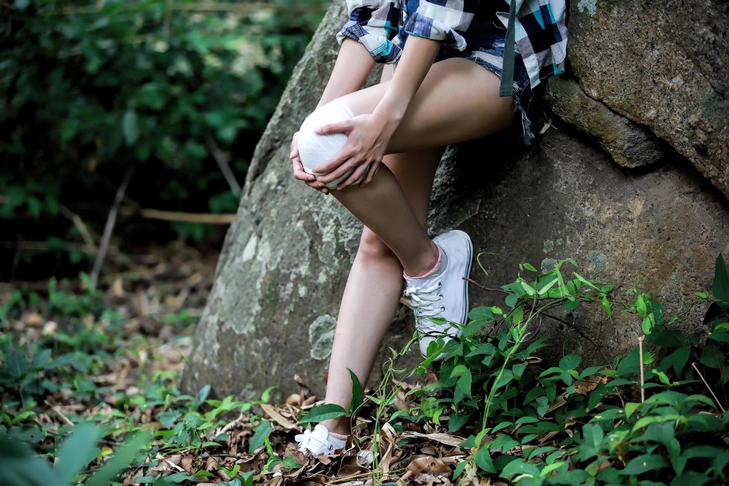 Abenteuer- oder Wanderfrau hat eine Verletzung am Knie foto