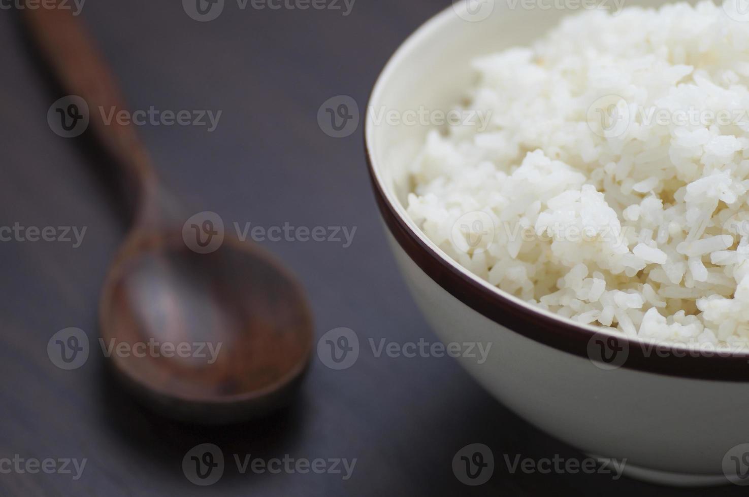 thailändischer Reis in Schüssel mit Holzlöffel auf Tisch foto
