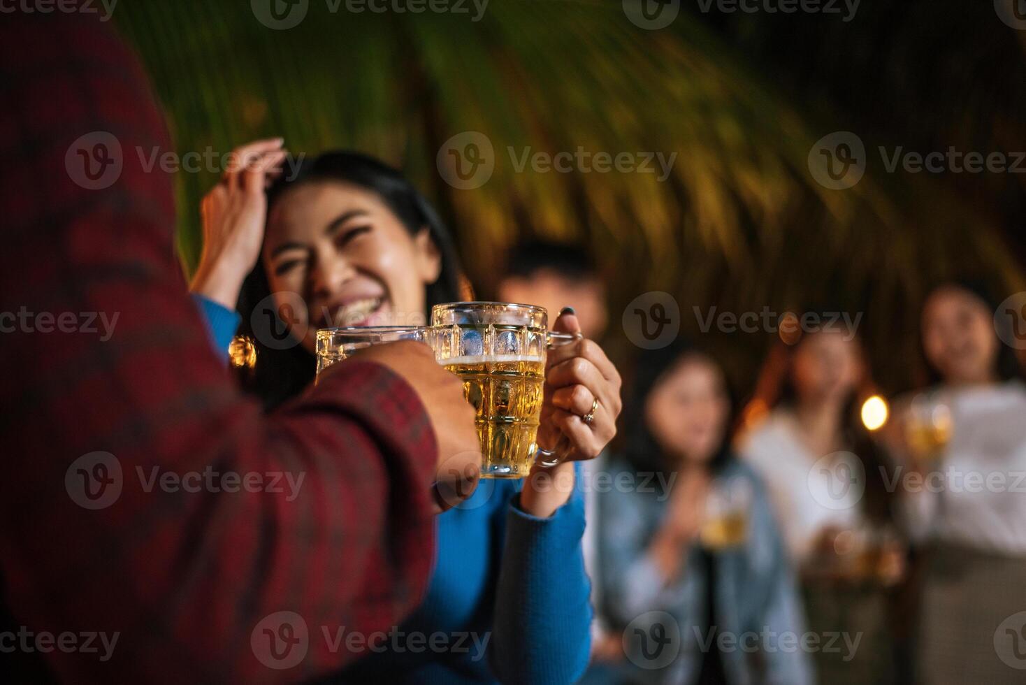 porträt glücklicher asiatischer freunde, die zusammen eine dinnerparty haben - junge leute, die biergläser abendessen im freien anstoßen - menschen, essen, trinken lebensstil, neujahrsfeierkonzept. foto