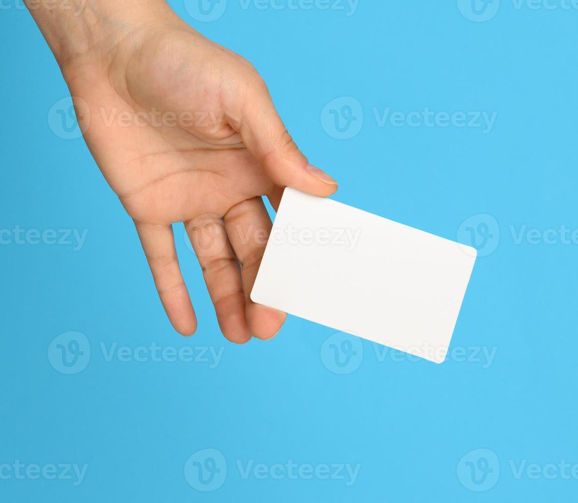 weiblich Hand halten ein Weiß schwarz Geschäft Karte, Blau Hintergrund foto