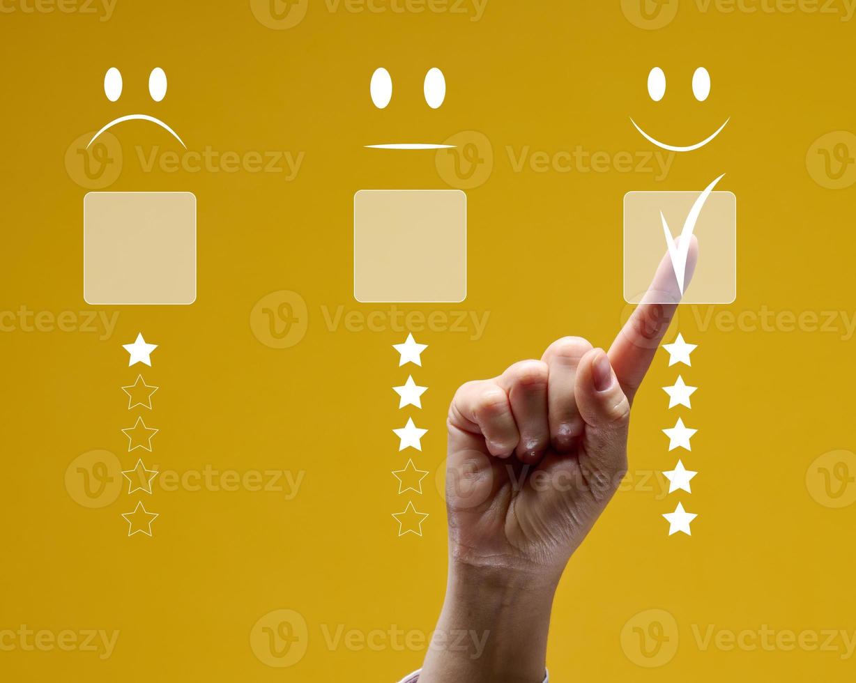 Konzept von Kunde Bedienung und Zufriedenheit. weiblich Hand berühren das virtuell Bildschirm auf das glücklich Emoticon Symbol zu erhalten Bedienung Befriedigung foto