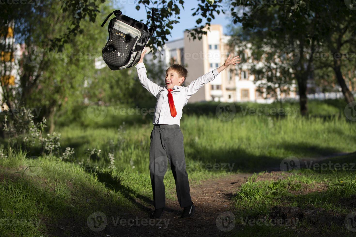 ein glücklich Schüler wirft oben seine Schule Rucksack und freut sich beim das Start von das Feiertage. das Ende von das Schule Jahr und das Anfang von das Feiertage. foto