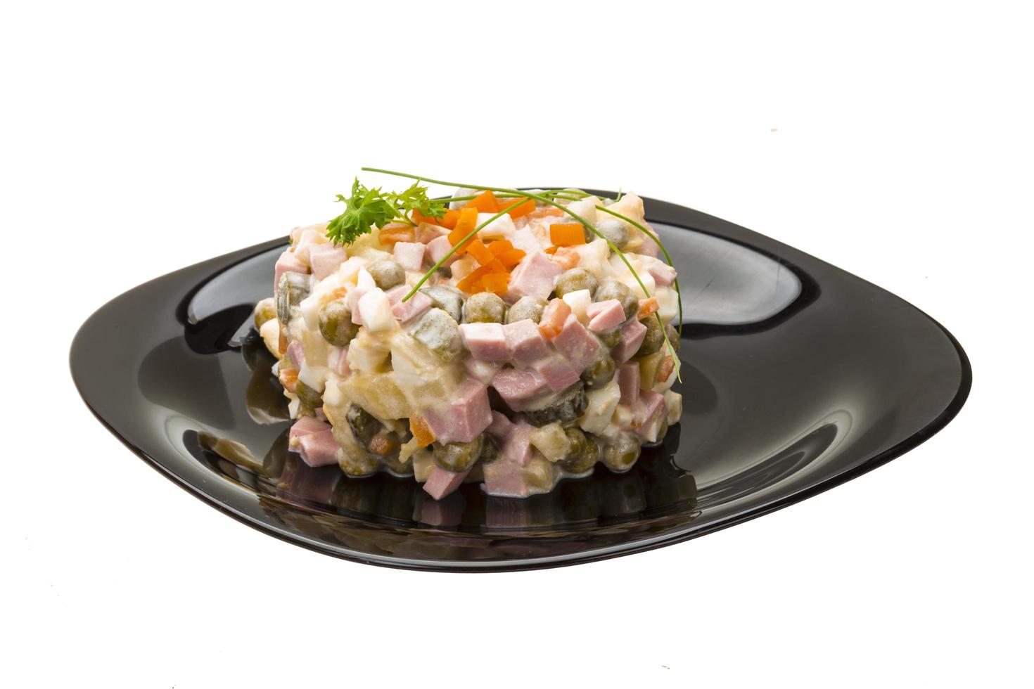 Russischer Salat auf dem Teller und weißem Hintergrund foto