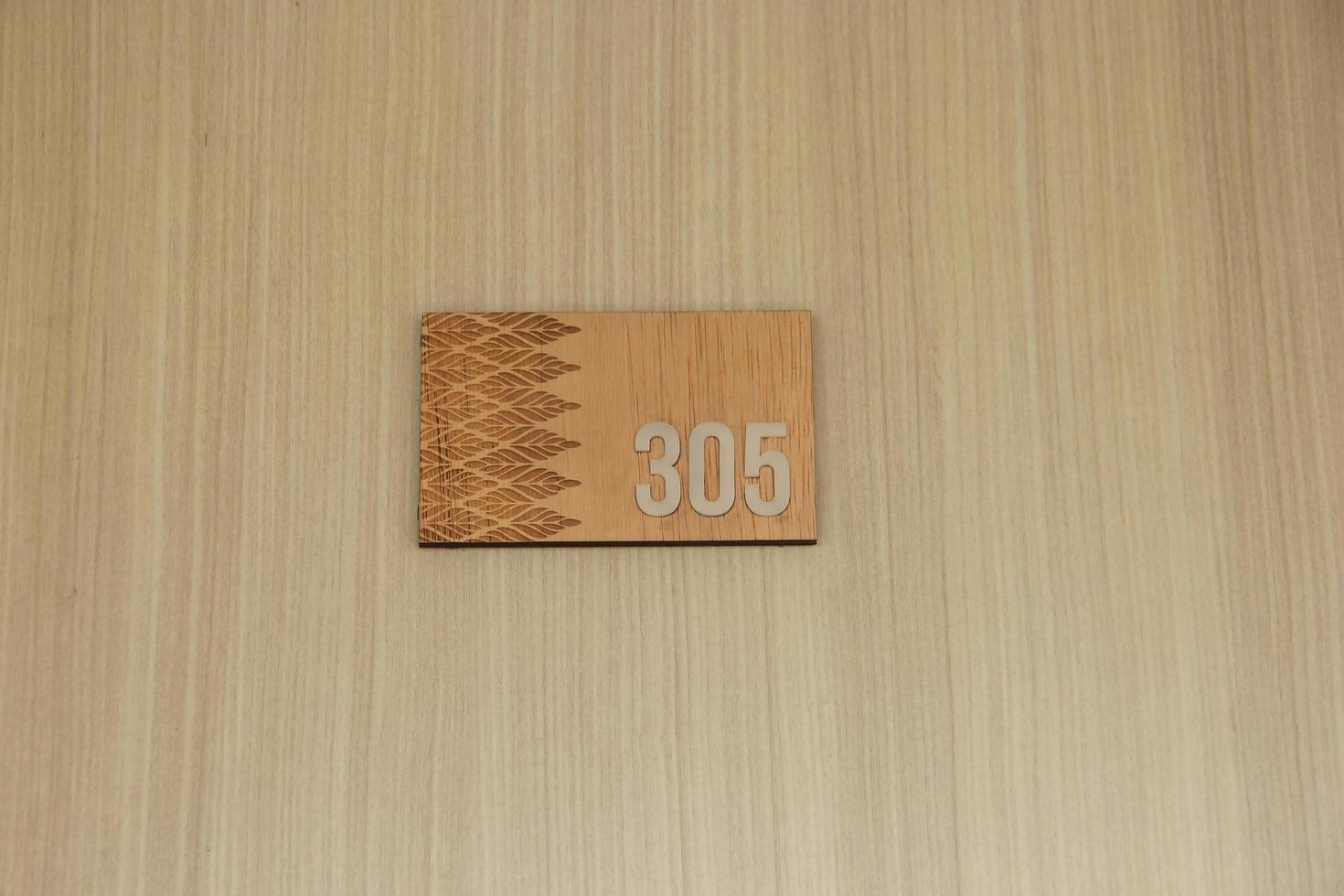 hölzern Wohnung, heim, oder Hotel Tür Fußboden Nummer 305 isoliert auf Holz Mauer mit Rechteck geformt Vorlage. foto
