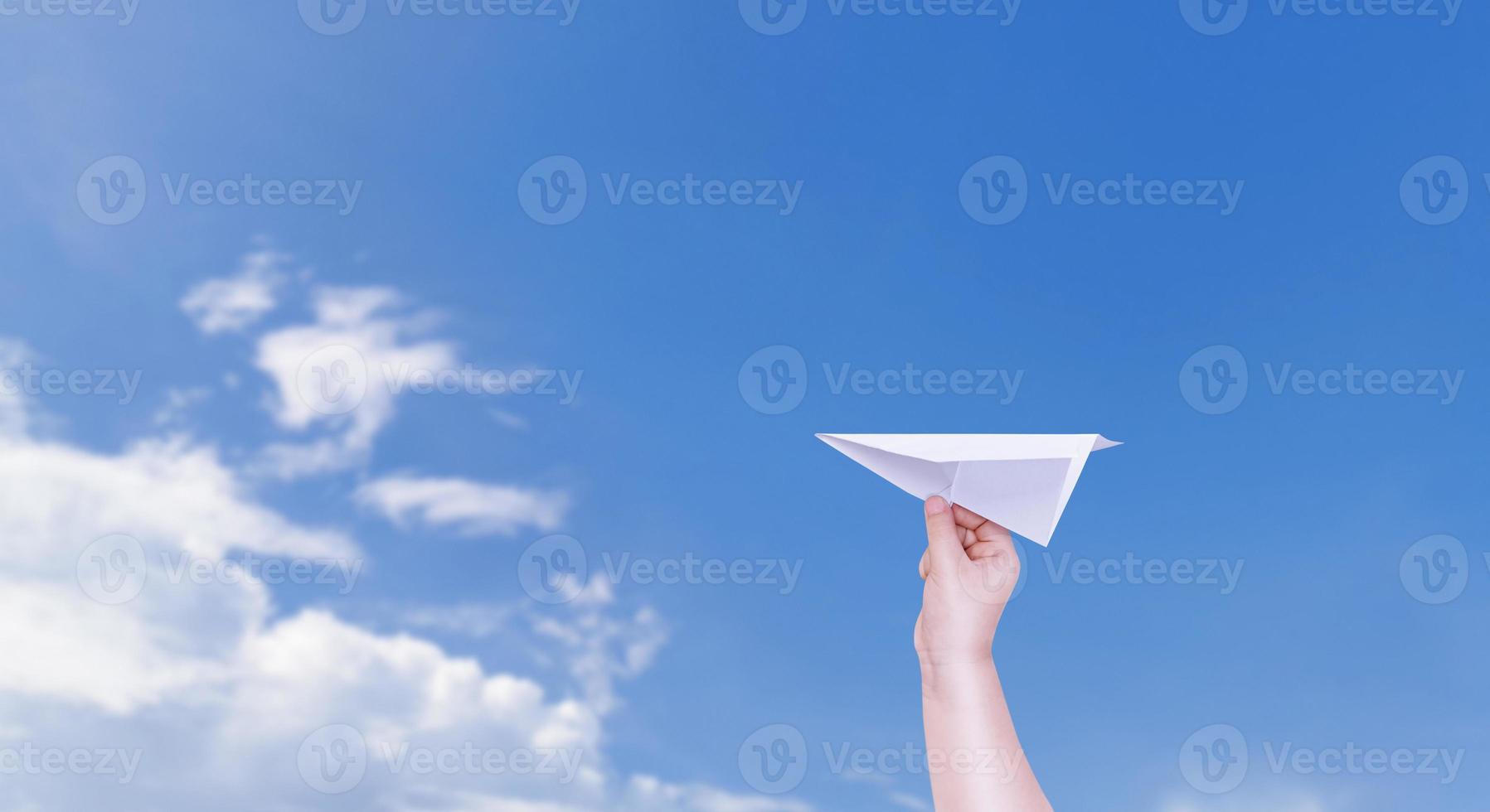 Junge Hand halten ein Papier Flugzeug das Hintergrund ist ein schön Himmel. foto