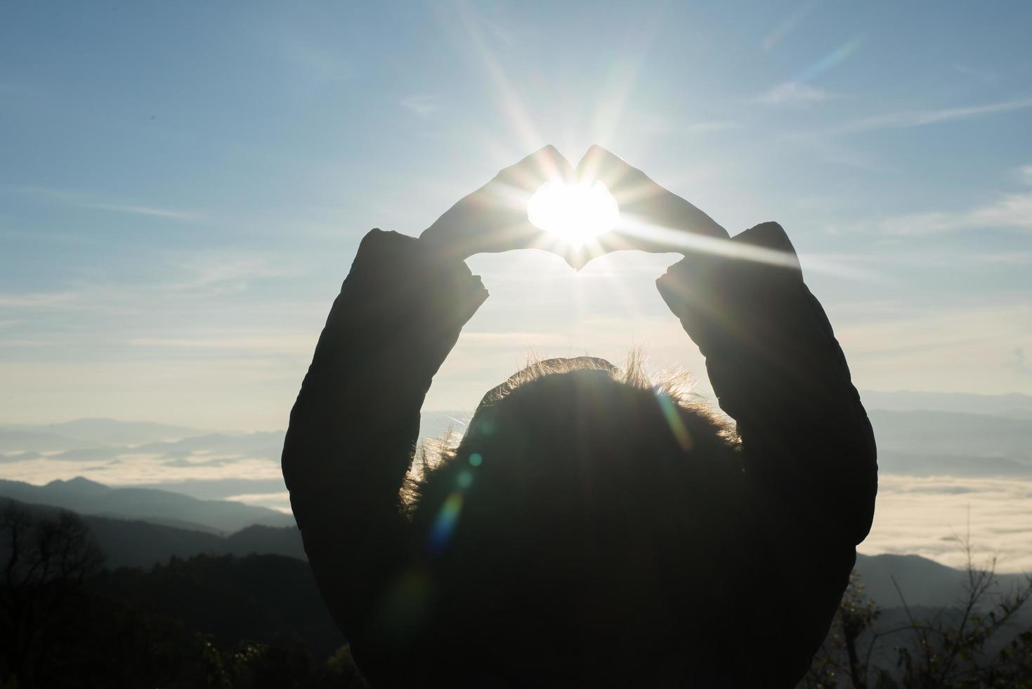 glückliche junge Frau Wanderer mit offenen Armen bei Sonnenuntergang angehoben foto