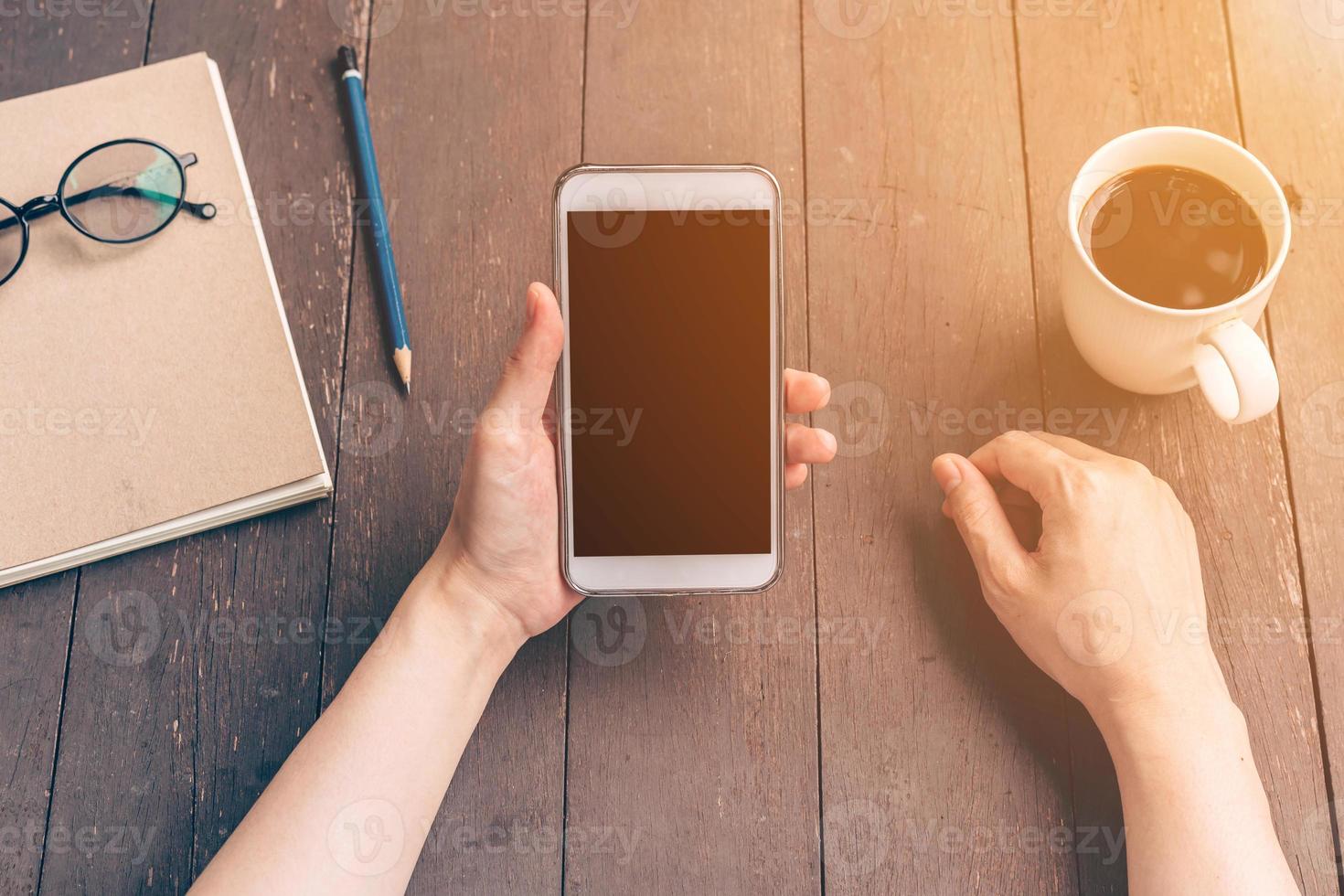 schließen oben Hand Asien Frau mit Telefon im Kaffee Geschäft mit Jahrgang Filter. foto