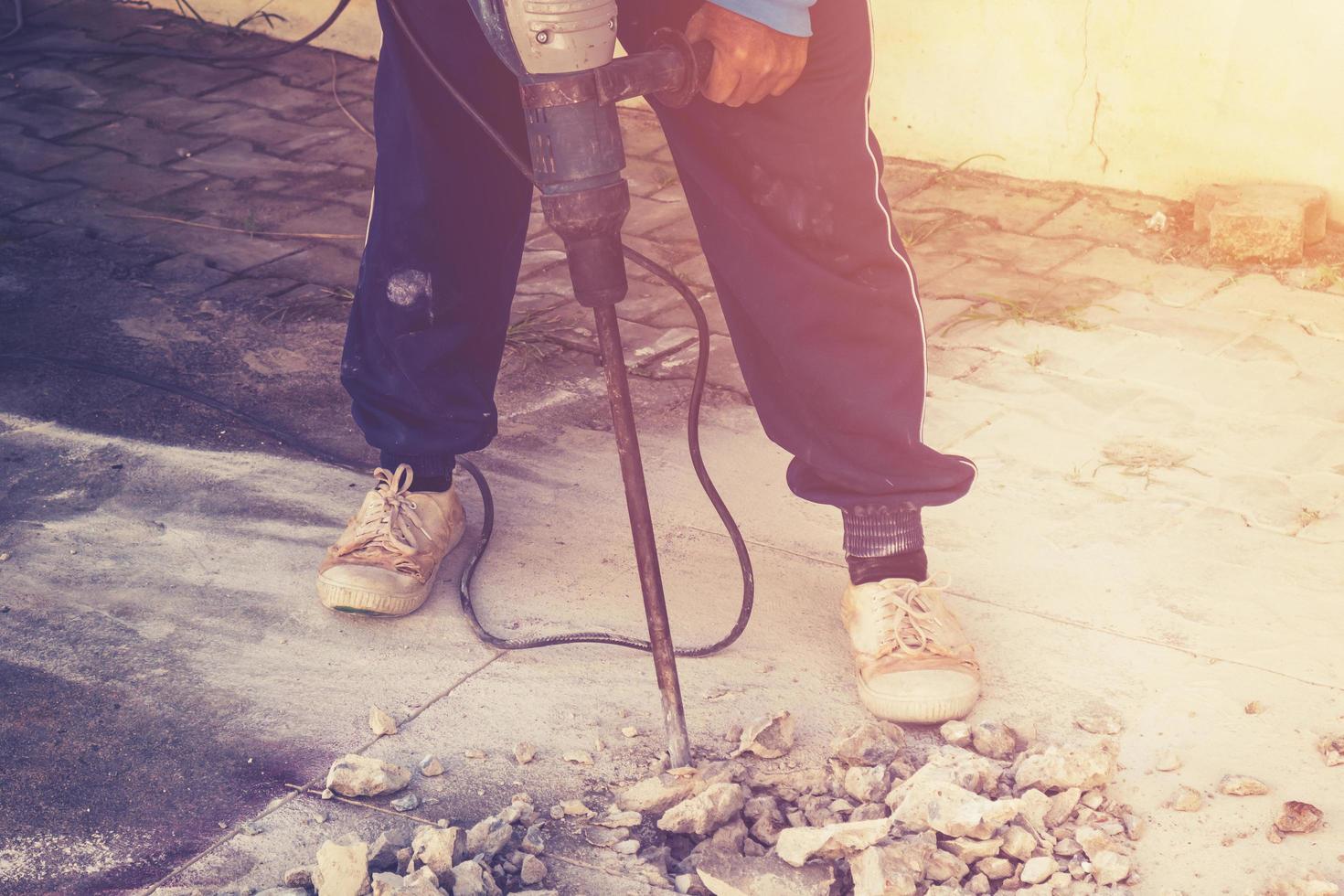 schließen oben Arbeiter Mann Mason Bohren Zement Beton Fußboden mit Maschine foto