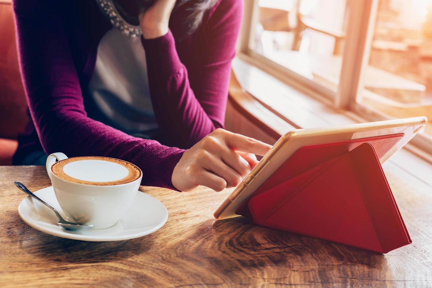 Frau mit Tablette Computer im Kaffee Geschäft mit Jahrgang Ton. foto