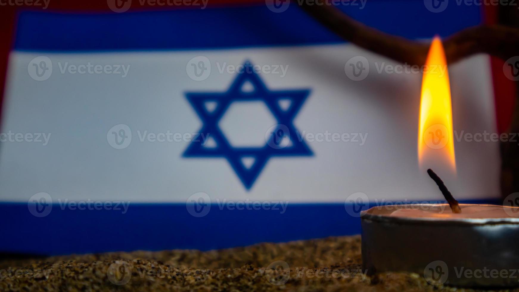 israelische flagge und davor brennende kerzen, holocaust-gedenktag foto