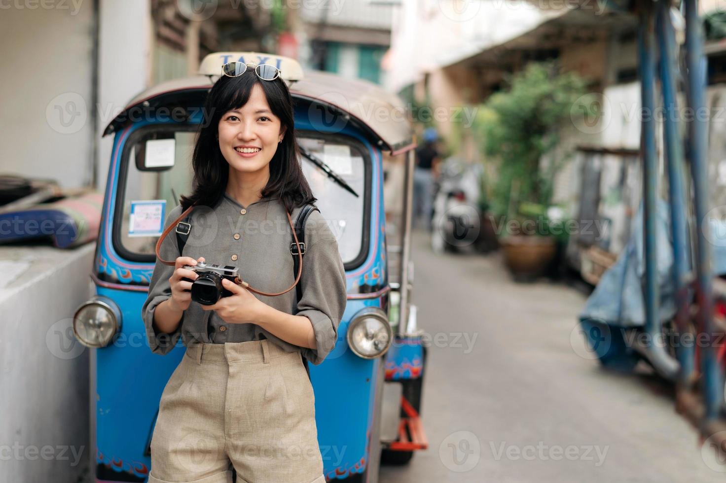 jung asiatisch Frau Rucksack Reisender Stehen ein Seite von Tuk Tuk Taxi auf Sommer- Urlaube beim Bangkok, Thailand. foto