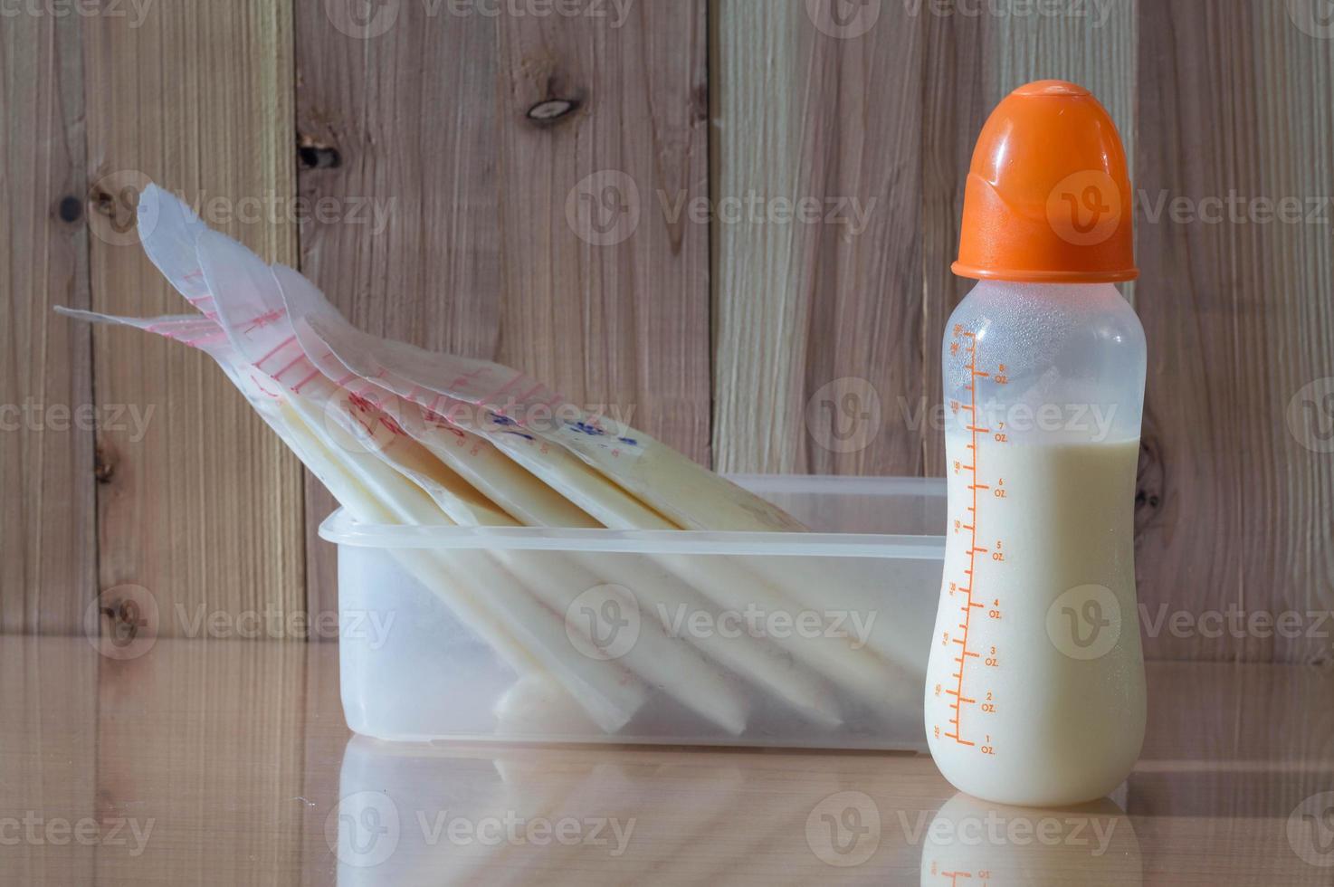 Muttermilch in der Flasche für Baby mit hölzernem Hintergrund foto