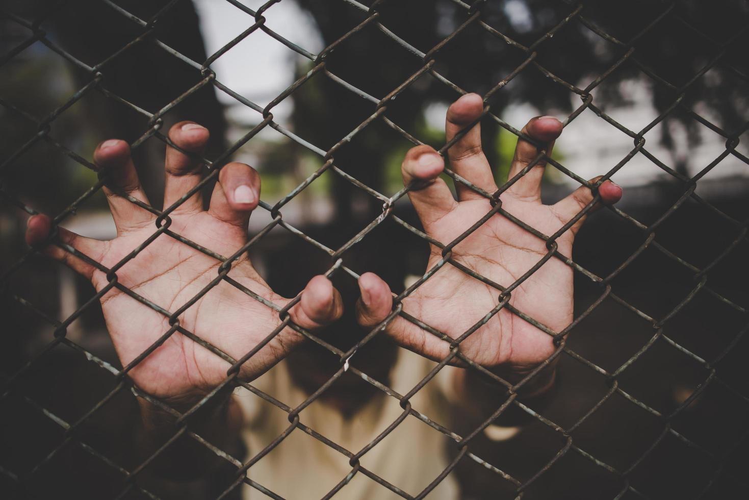 Hand mit Metallzaun, keine Freiheit fühlen foto