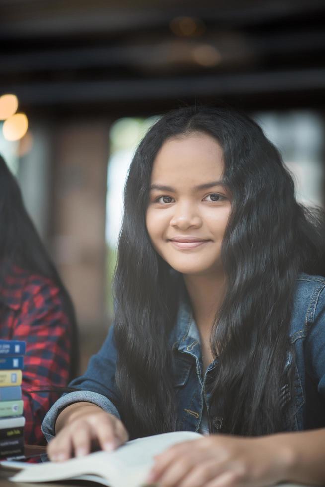 Porträt der jungen Frau, die im Café des Cafés lächelt foto