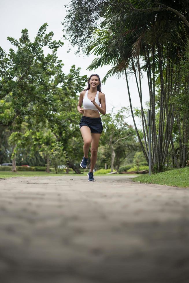 junge sportliche Frau, die im Park läuft foto