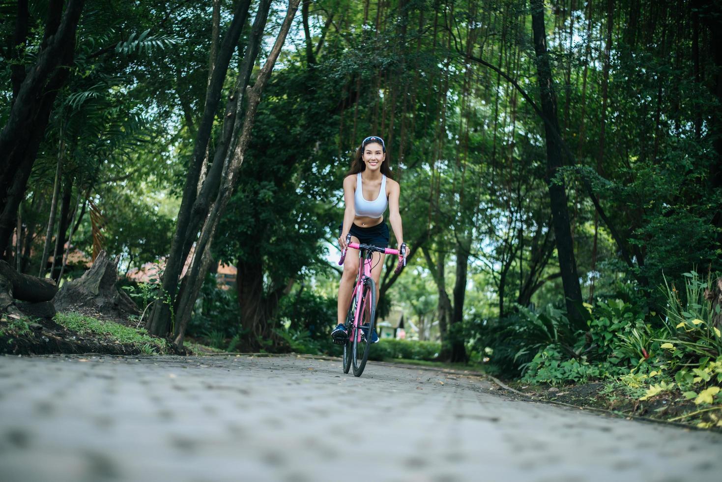 junge Frau, die ein Fahrrad im Park reitet foto