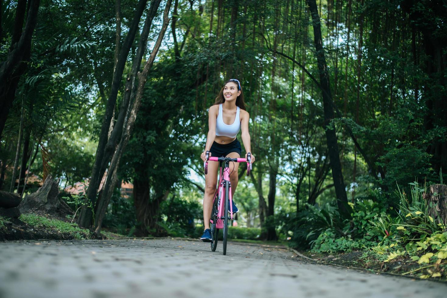 junge Frau, die ein Fahrrad im Park reitet foto