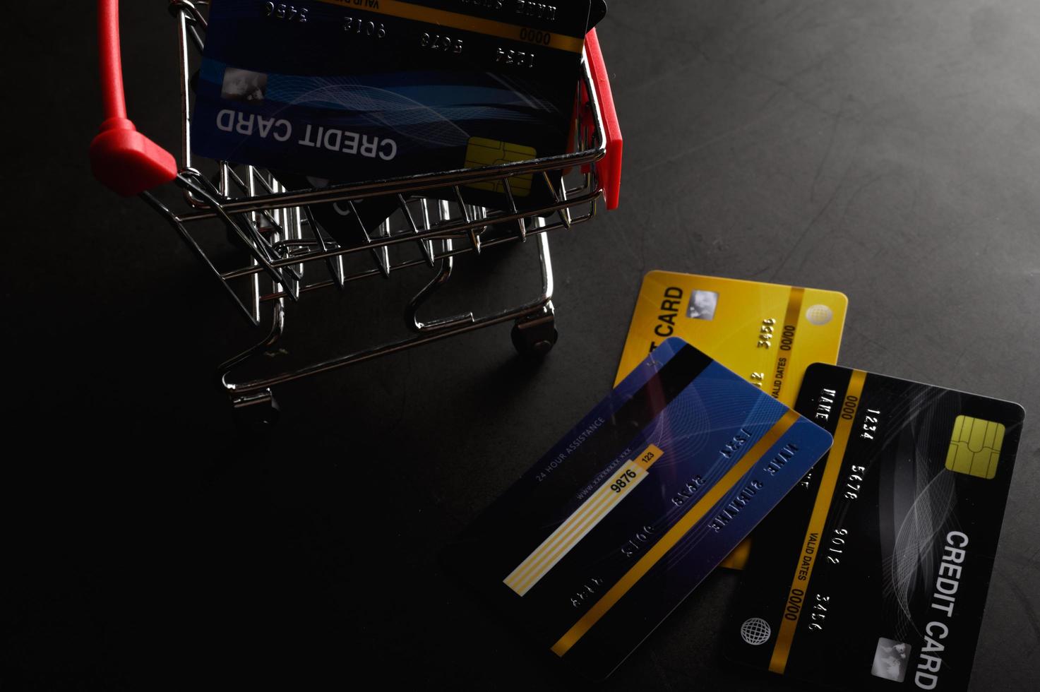 Kreditkarten im kleinen Einkaufswagen mit Kopierplatz foto